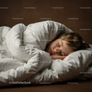 Peaceful young boy sleeping under warm white duvet