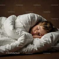 Peaceful young boy sleeping under warm white duvet