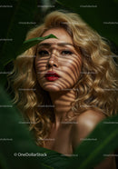 Glamorous Woman with Curly Blonde Hair Among Tropical Leaves
