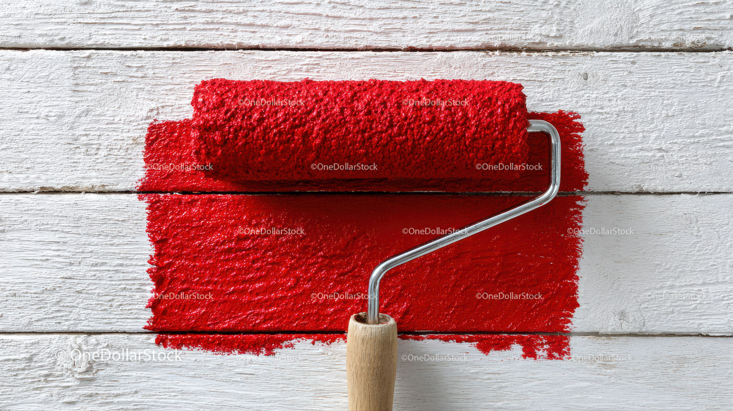 Red Paint Roller Applying Bright Red Paint on White Wooden Surface