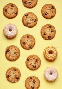 Assorted chocolate chip cookies and sprinkled donuts on yellow