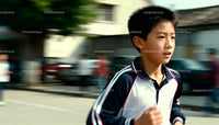 Focused boy running outdoors on a sunny day
