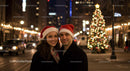 Couple Wearing Santa Hats in Festive City Lights