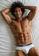 Smiling fit man relaxing on bed in white underwear
