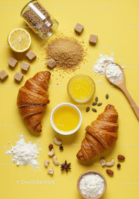 Fresh croissants with baking ingredients on yellow surface
