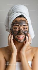 Young Woman Applying Black Charcoal Face Mask with Towel on Head