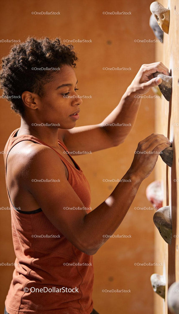 Focused Woman Climbing Indoor Rock Wall