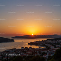 Beautiful Sunset Over Coastal Town with Boats and Hills