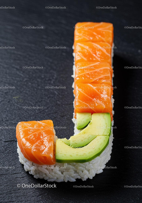 Fresh salmon and avocado sushi roll on black slate