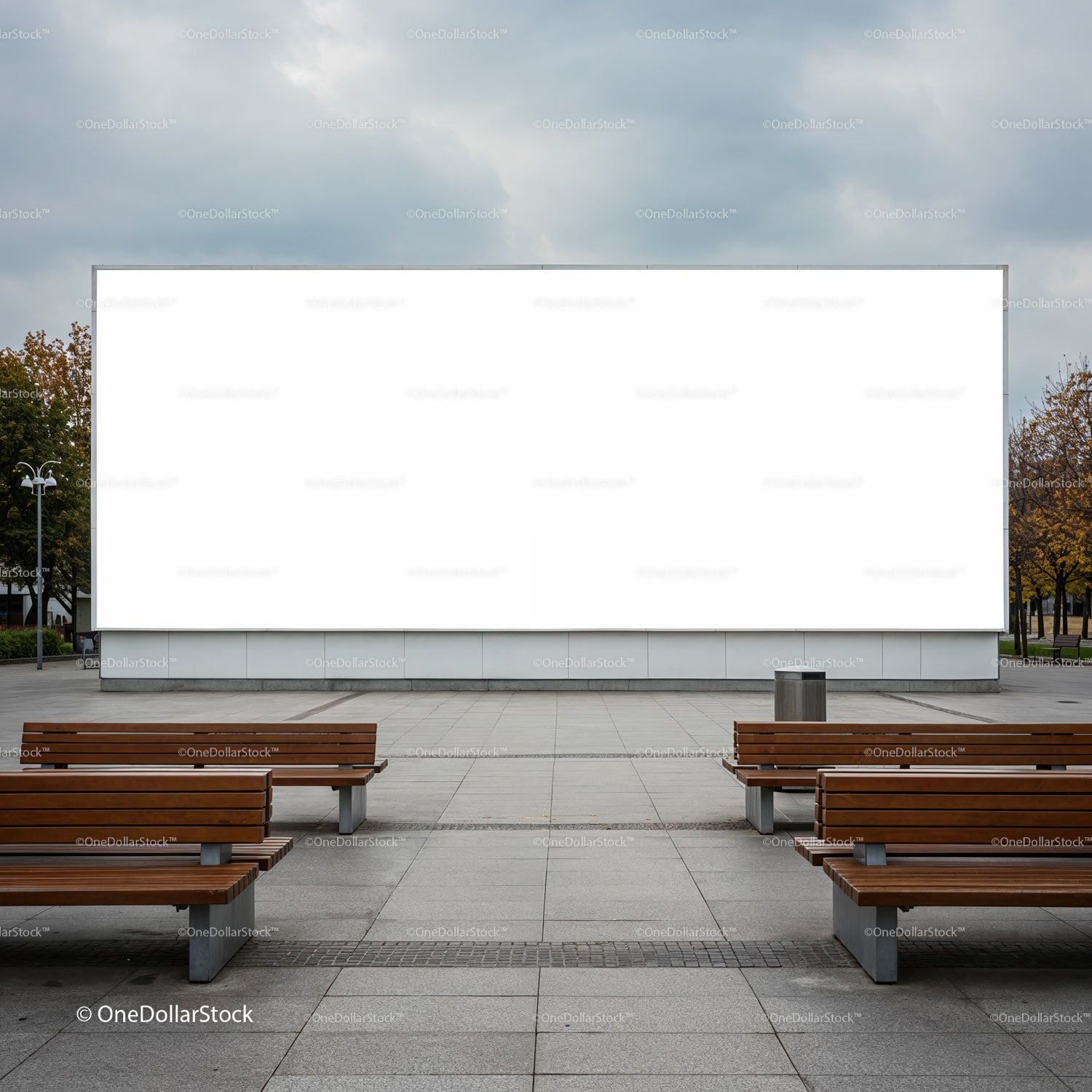Empty outdoor benches facing large blank billboard