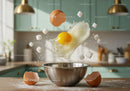 Floating cracked egg and sugar cubes over mixing bowl
