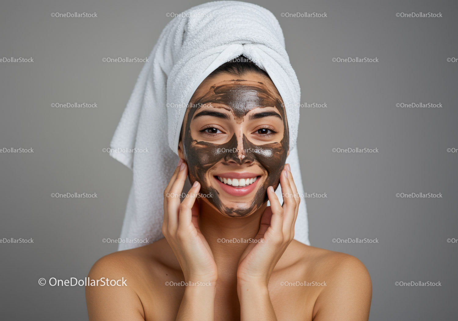 Young woman with facial clay mask and towel on head