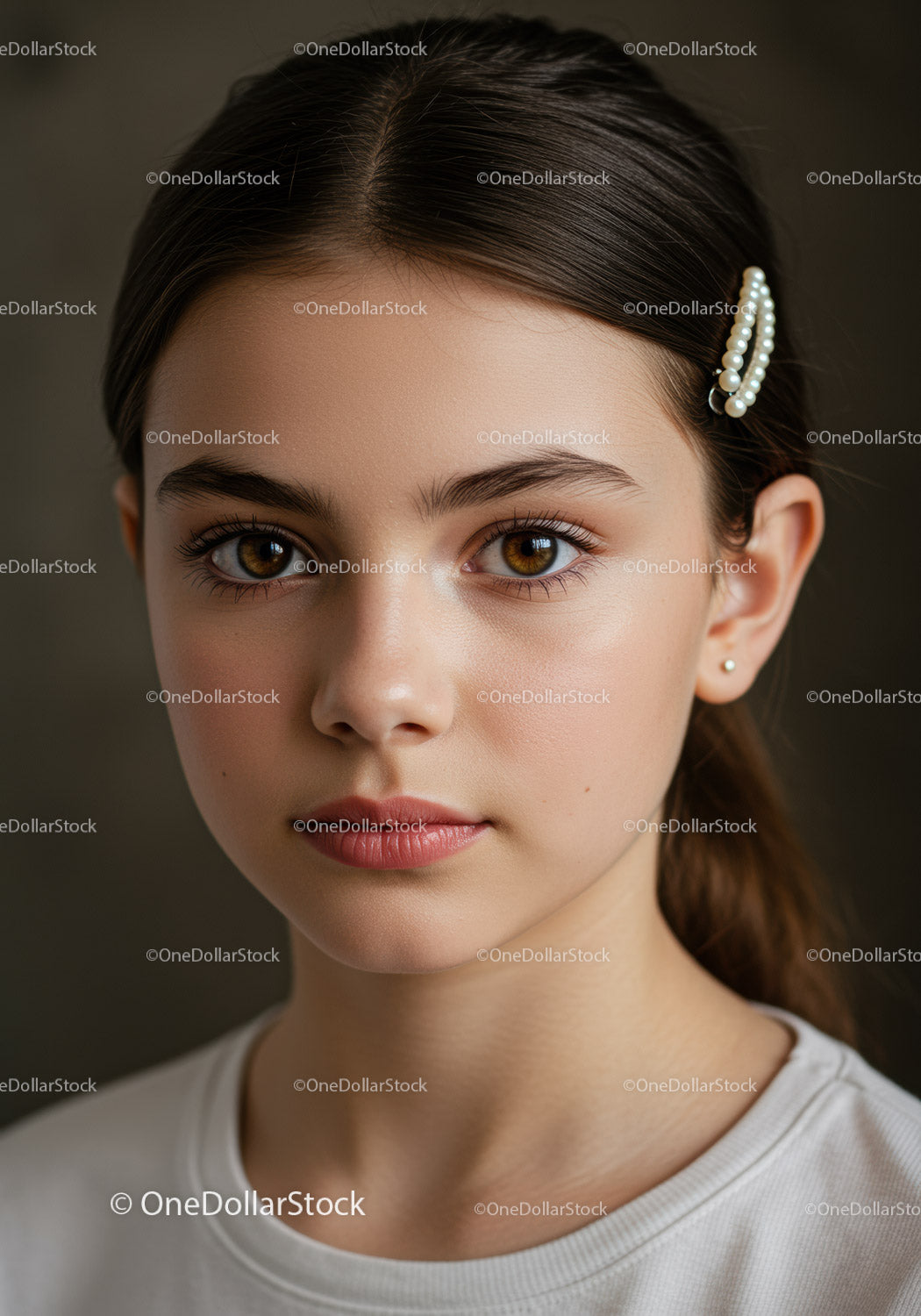 Portret młodej kobiety z perłową spinką do włosów i brązowymi oczami