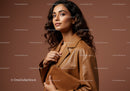 Elegant Woman in Leather Jacket Holding Clutch On Brown Background