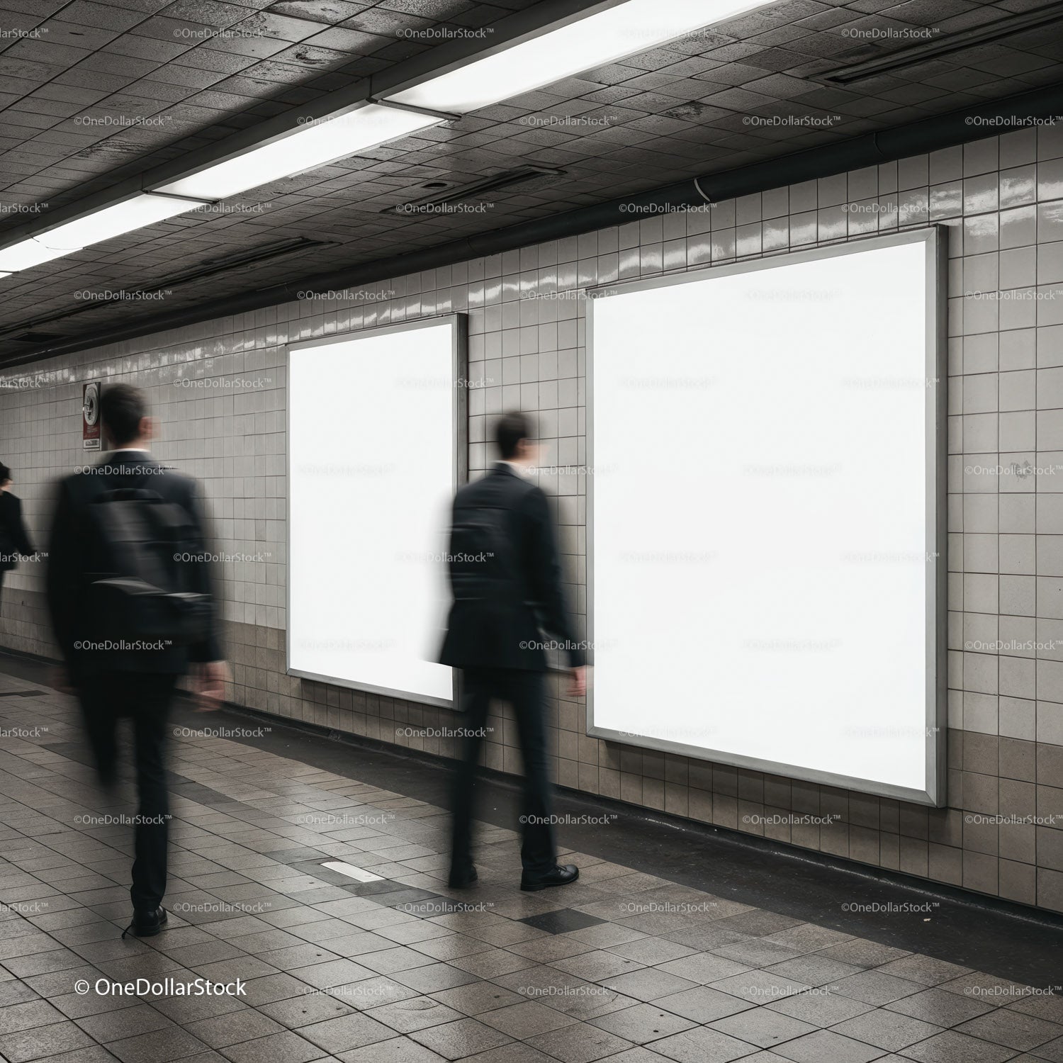 Blurred commuters passing blank advertising panels underground