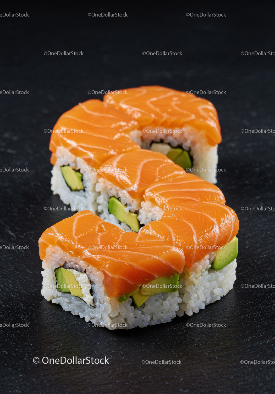 Świeże rolki sushi z łososiem i awokado na czarnym łupku