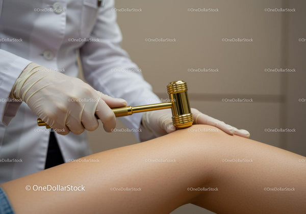 Dermatolog wykonujący zabieg na cellulit za pomocą specjalistycznego młoteczka