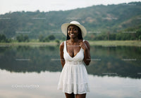 Smiling Woman in White Dress by Lakeside Nature Scene