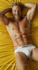 Smiling muscular man relaxing on bright yellow bed