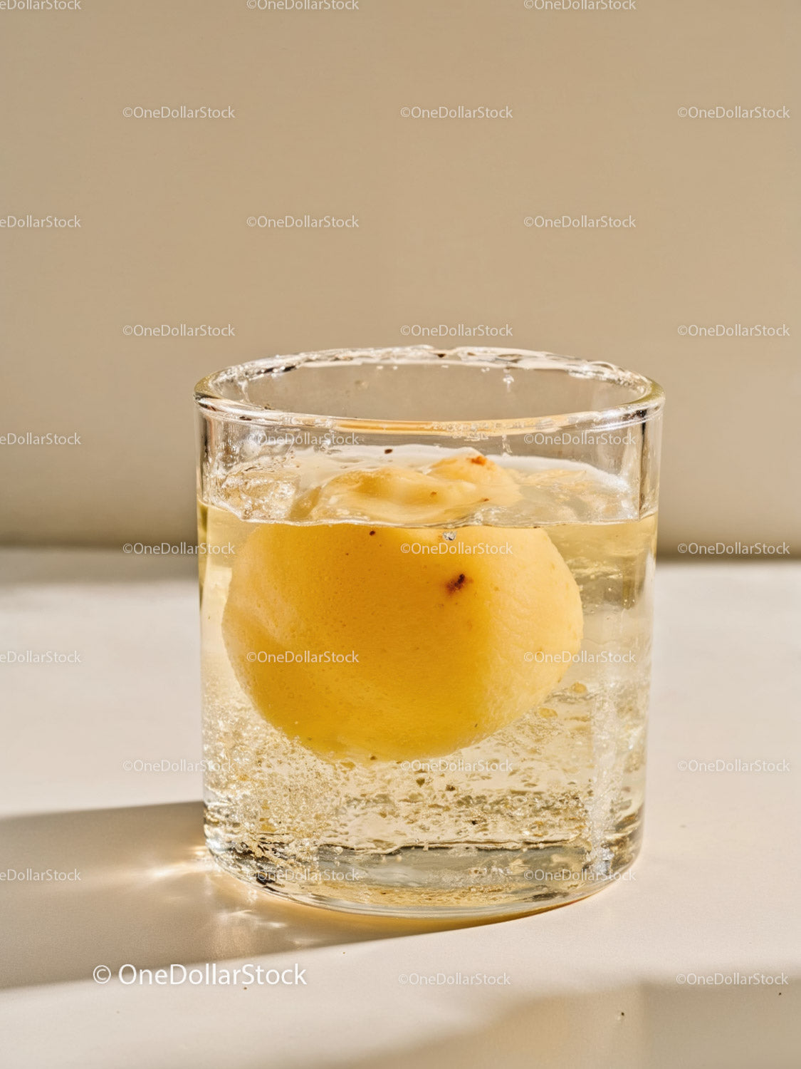 Clear glass with floating peach in sparkling water