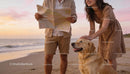 Couple exploring beach with golden retriever at sunset