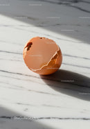 Cracked brown egg shell on marble surface in sunlight