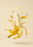 Peeled banana with floating banana slices on beige background