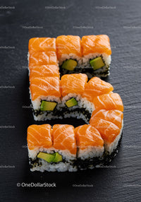 Sushi Rolls Arranged in Number Five Shape on Slate