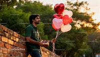Man Holding Heart Balloons and Chocolates Outdoors