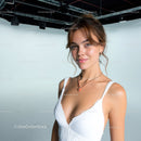 Confident Young Woman Smiling in White Dress with Jewelry