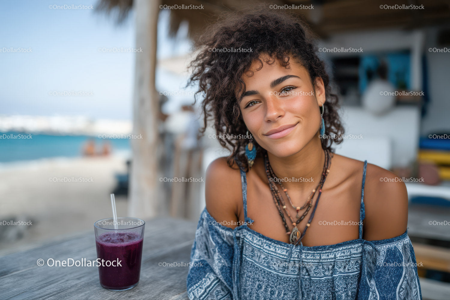 Młoda kobieta uśmiecha się w kawiarni przy plaży w letniej modzie