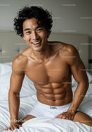 Smiling muscular man in white underwear on bed