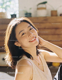 Young woman smiling warmly in bright natural light