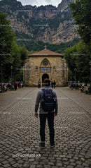 Young traveler exploring historic mountain chapel pathway