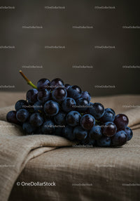 Fresh ripe black grapes on rustic fabric background