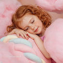 Peaceful redhead girl resting on pastel cotton candy