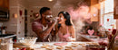 Couple having fun baking heart shaped cookies together