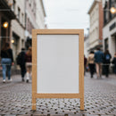Blank wooden sidewalk sign on urban cobblestone street