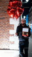 Man Holding Heart Balloons and Chocolate Gift on Street