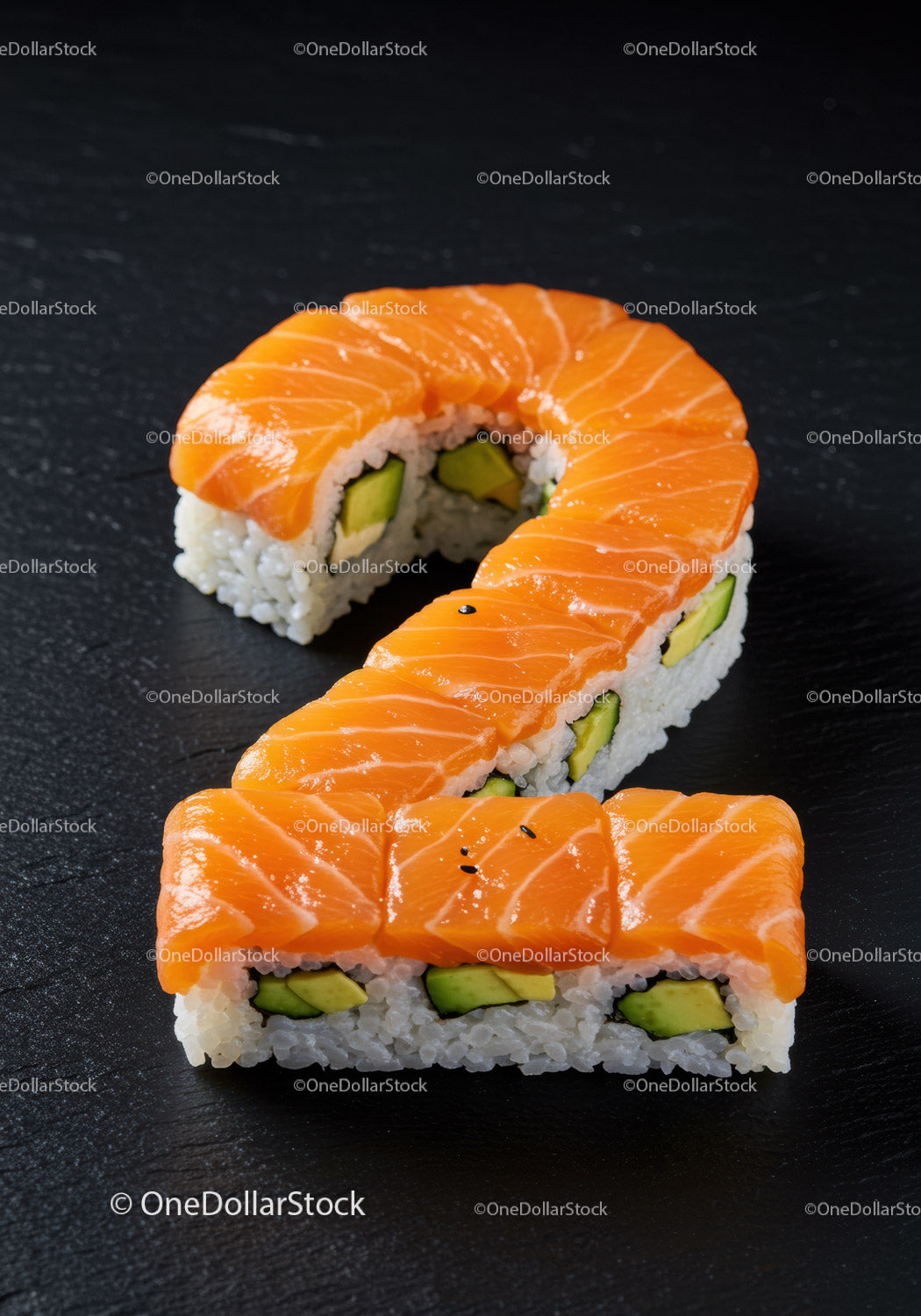 Rolki sushi z łososiem uformowane w kształt cyfry dwa na czarnym łupku