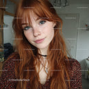 Young Red-Haired Woman with Blue Eyes in Casual Indoor Setting