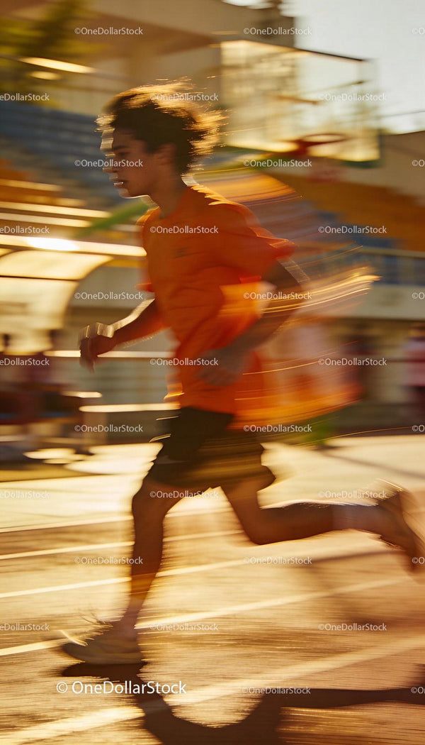 Young Athlete Sprinting Outdoors at Sunset Light