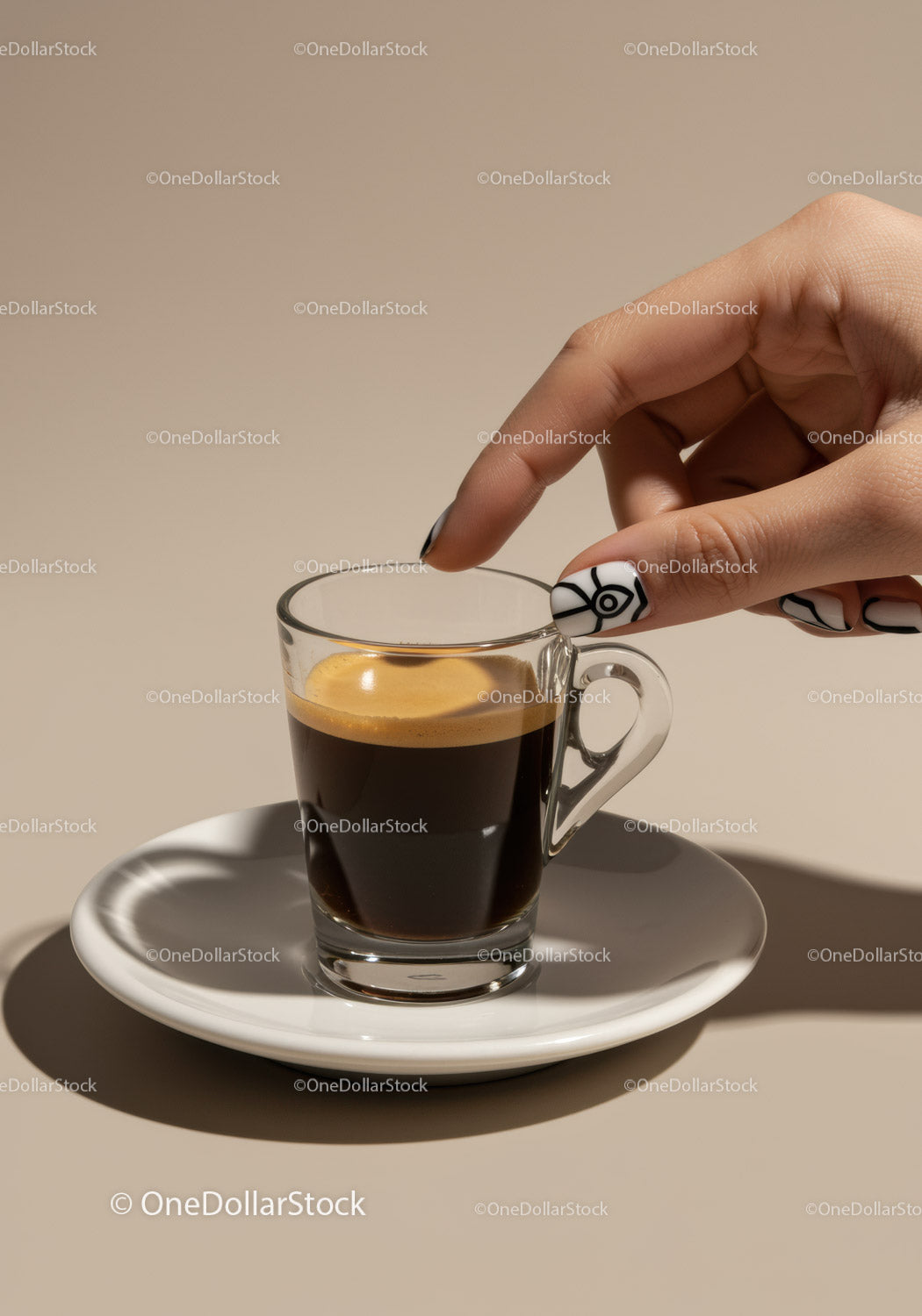Dłoń sięgająca po szklankę espresso na białym spodku