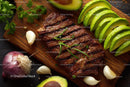 Juicy Grilled Steak with Fresh Avocado and Garlic on Rustic Board