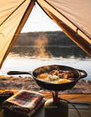 Camping breakfast with eggs and mushrooms by the lake