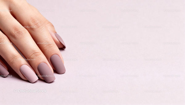 Close-up of manicured hand with matte pink nails