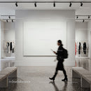 Woman walking past blank gallery wall in modern space