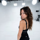 Confident Young Woman in Black Dress in Professional Studio