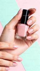 Close up of hands holding pink nail polish bottle