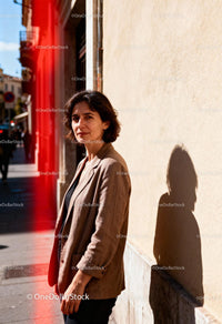 Woman standing on sunny urban street with shadow